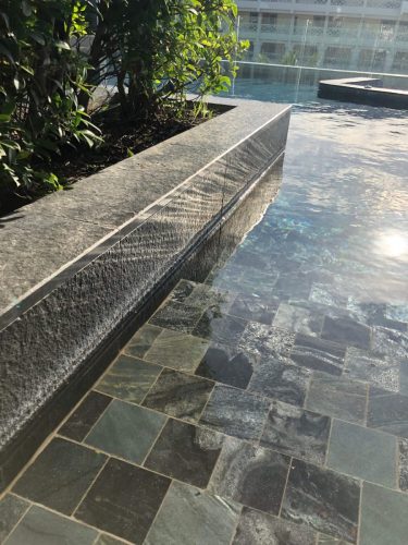 hsn-black-basalt-flamed-pool-coping-planter-installed-reflection